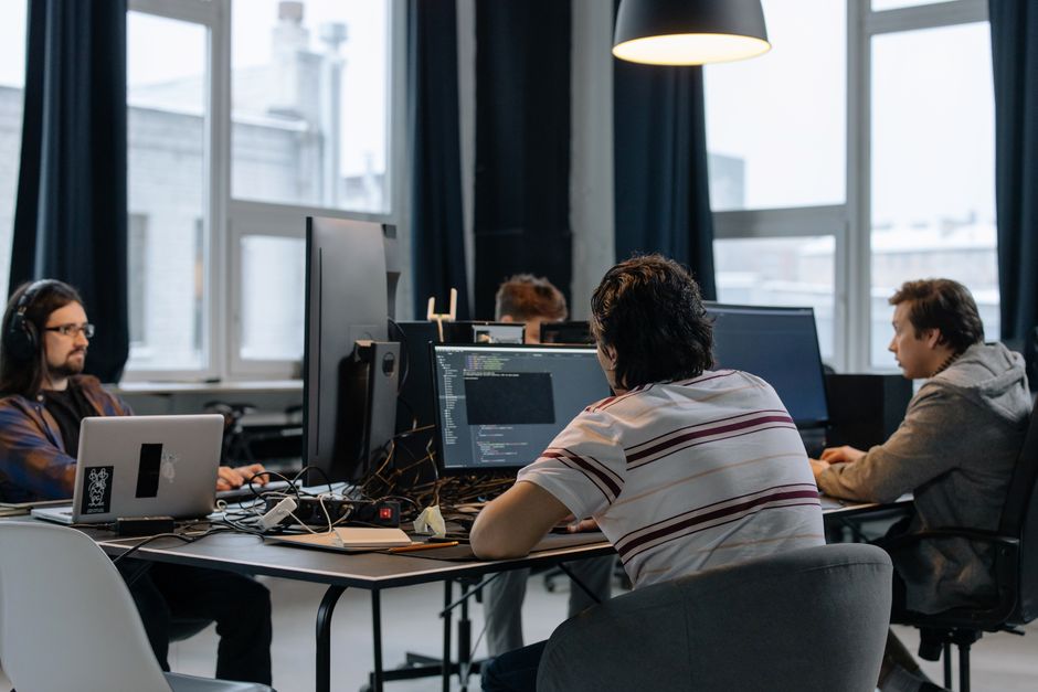 Tim developera radi zajedno na računalima u modernom tech uredu