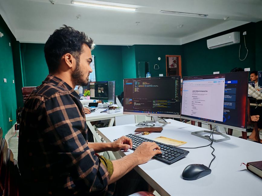 Softverski developer radi na kodu na dvostrukom monitoru u modernom uredu